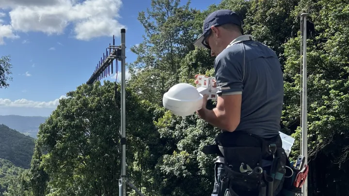 Technician installing WiFi access point outdoors